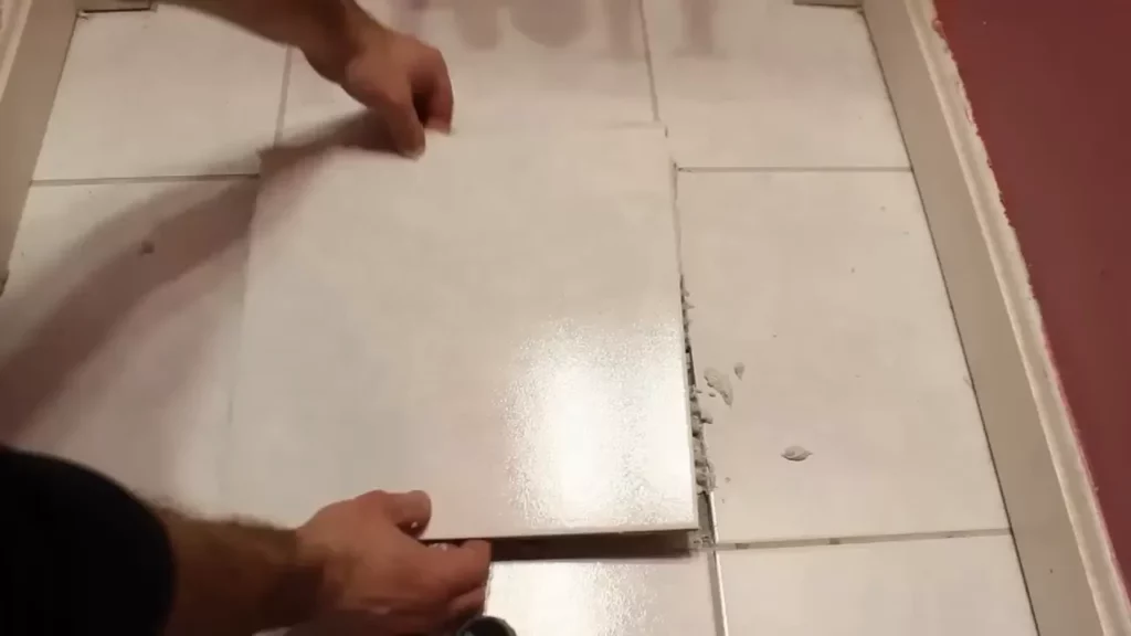 Placing a new tile carefully into the prepared space for installation